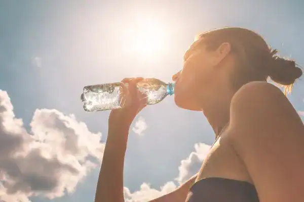 Hydration: The Secret Ingredient for a Toned Stomach and Enhanced Fitness 3 Image of woman drinking water to hydrate Beccles after run.
